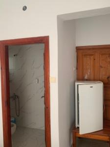 a bathroom with a refrigerator and a shower at Kristal pansiyon in Ortaca