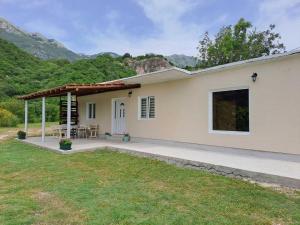a white house with a patio and a table at Village House DIMS in Kotor
