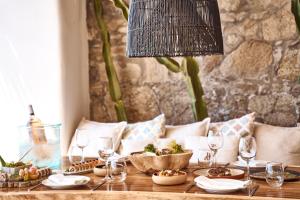 a table with wine glasses and a bowl of fruit at Hippie Chic Hotel in Agios Ioannis Mykonos