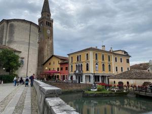 a group of buildings and a church with a clock tower at Casa Eva in Bibione
