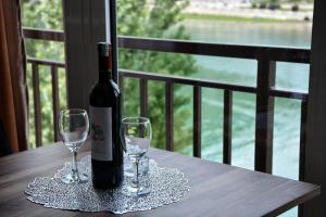 a bottle of wine sitting on a table with two glasses at Aluna 4 in Višegrad