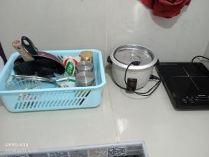 a blue dish basket sitting on a counter next to a laptop at RY Nest in Malaybalay +2 photos