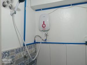 a shower in a bathroom with a red button on the wall at RY Nest in Malaybalay