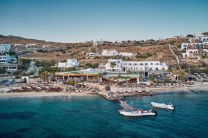 two boats in the water next to a beach at Hippie Chic Hotel in Agios Ioannis Mykonos