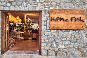 a stone building with a sign that reads hippie fire at Hippie Chic Hotel in Agios Ioannis Mykonos