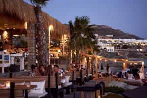a group of people sitting at a restaurant at night at Hippie Chic Hotel in Agios Ioannis Mykonos