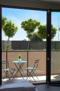 a patio with two chairs and a table and a table at Virtual - Superior Apartments Milano Opera in Opera