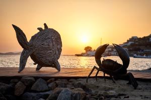 a statue of a bird on a dock near the water at Hippie Chic Hotel in Agios Ioannis Mykonos