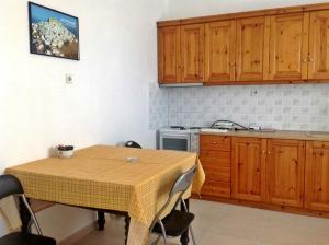 a kitchen with a table and a kitchen with wooden cabinets at Papanikola House 2 in Astypalaia