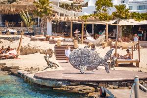 a sculpture of a fish on a beach at Hippie Chic Hotel in Agios Ioannis Mykonos