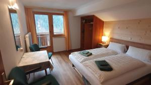 a bedroom with two beds and a table and chairs at Haus Salzmann in Sankt Gallenkirch