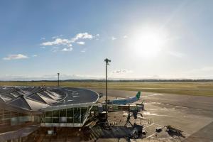 an airplane is parked at an airport at Moxy Lyon Airport in Saint-Exupéry