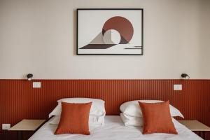 a hotel room with a bed with orange pillows at Hotel San Marco Sestola in Sestola
