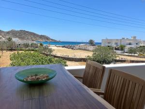 a bowl of rocks on a wooden table with a view of the beach at Sea sound in Mylopotas