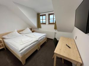mały pokój z łóżkiem i stołem w obiekcie Hotel Rankl w mieście Horská Kvilda +37 zdjęć