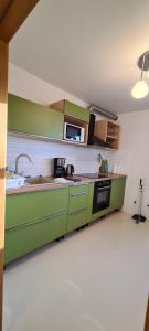 a kitchen with green cabinets and a microwave at Grund in Ólafsvík in Ólafsvík