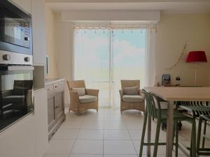 eine Küche und ein Esszimmer mit Tisch und Stühlen in der Unterkunft Appart du golf in Saint-Jean-de-Monts