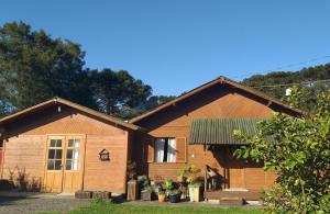 a wooden house with a green roof at Pousada Doce Vida in Urubici