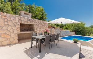 een patio met een tafel met een parasol en een zwembad bij Stunning Home In Poljica With Kitchen in Poljica +30 foto's