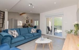 een woonkamer met een blauwe bank en een tafel bij Stunning Home In Poljica With Kitchen in Poljica