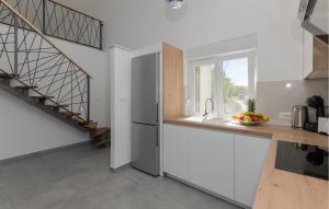 een keuken met een roestvrijstalen koelkast en een trap bij Stunning Home In Poljica With Kitchen in Poljica