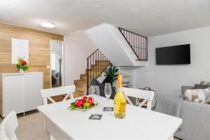 a kitchen and living room with a table with a bottle of wine at Holliday house Smokvica in Jadranovo