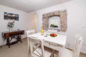 a kitchen and dining room with a white table and chairs at Holliday house Smokvica in Jadranovo +12 photos