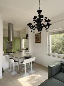 a kitchen with a dining room table and a chandelier at Charm in centre, sunset, movida! in Milano Marittima