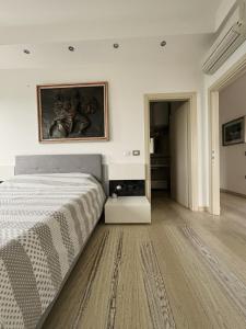 a bedroom with a bed and a painting on the wall at Charm in centre, sunset, movida! in Milano Marittima