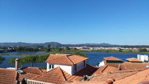 a group of roofs with a river in the background at Refúgio do Cais in Esposende