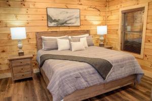 ein Schlafzimmer mit einem Bett und zwei Lampen an Tischen in der Unterkunft Spacious 2800 sq ft-Cozy Wood Cabin-NEW BUILD in Pigeon Forge