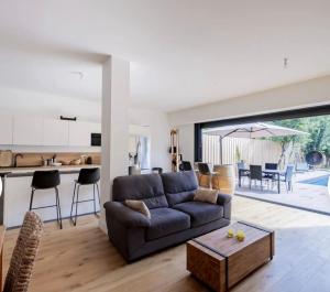 ein Wohnzimmer mit Sofa und Tisch in der Unterkunft Villa du Bouscat in Le Bouscat