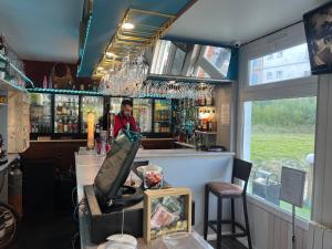 a bar with a man standing behind a counter at Hotel Des Bains in Veulettes-sur-Mer