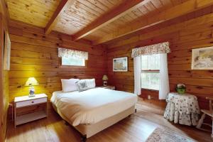 a bedroom with a bed in a wooden cabin at Saco River Hideaway in Bartlett