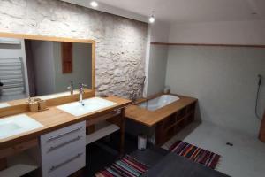 a bathroom with a tub and a sink and a mirror at maison de village in Laplume +15 photos