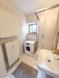 a small bathroom with a washer and dryer in it at Two room Apartment in Dresden Neustadt with balcony in Dresden +18 photos