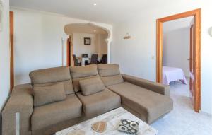 a living room with a brown couch and a bedroom at Cozy Apartment In Almunécar in Almuñécar