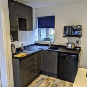 a small kitchen with a sink and a stove at The Orchid in Gillingham +5 photos