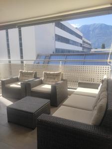 a balcony with chairs and couches on a building at Casa Renoir - Schritte zum Zee in Locarno