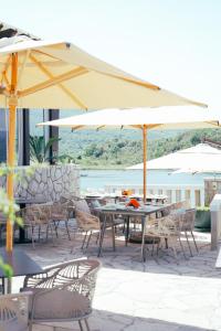 een patio met tafels, stoelen en parasols bij Luxury Sea Residence by Kristina in Tivat