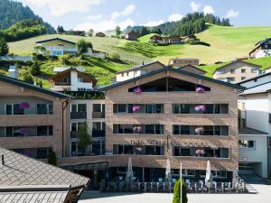 un hotel con una collina verde sullo sfondo di Kräuter & Spa-Hotel Das Schäfer - Adults only a Fontanella