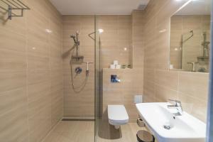 a bathroom with a shower and a toilet and a sink at Spokojne Wczasy in Mielno +70 photos
