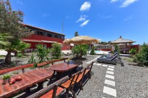 a table and benches with a table and umbrella at Ca'Sita Salobre Pueblo by VillaGranCanaria in San Bartolomé de Tirajana +40 photos
