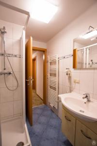 a bathroom with a shower and a sink and a tub at Gästehaus Leypold in Murau