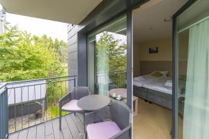 a balcony with a bed and a table and chairs at Spokojne Wczasy in Mielno