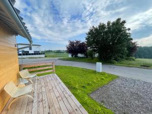 a wooden deck with two chairs and a bench at TinyHaus #1 Hülben - Ortsrand - kostenlose Parkplätze in Hülben