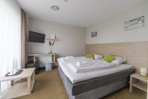 a bedroom with a large bed with green pillows at Spokojne Wczasy in Mielno