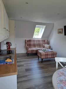 a living room with a couch and a table at Pension Sturmmöwe in Norddorf