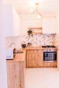 a kitchen with white cabinets and a sink and a stove at Riverside White Apartment in Satu Mare