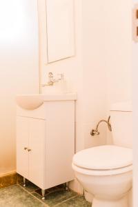 a white bathroom with a sink and a toilet at Riverside White Apartment in Satu Mare